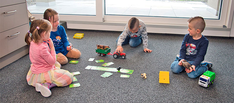 Vier Kinder am Memory spielen im Kinderhort der Beutler Nova